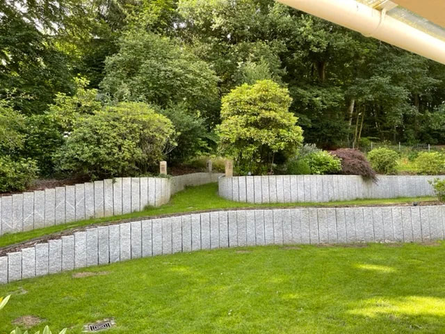 Garten mit Granitstelen und Beleuchtung